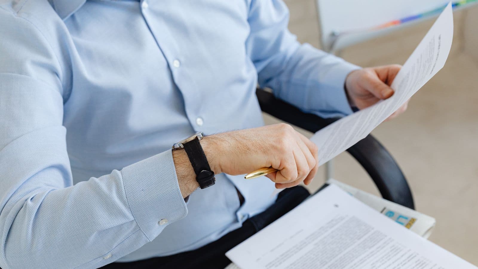 Belgische ondernemer bekijkt administratieve documenten aan zijn bureau, ter illustratie van het verschil tussen ondernemingsnummer en btw-nummer