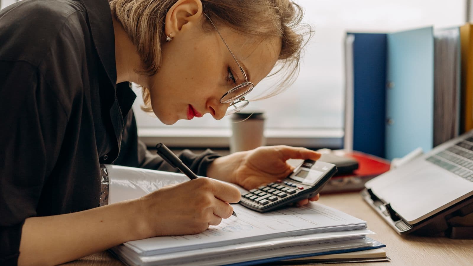 Accountant checking an intra-EU VAT number on a laptop at the office