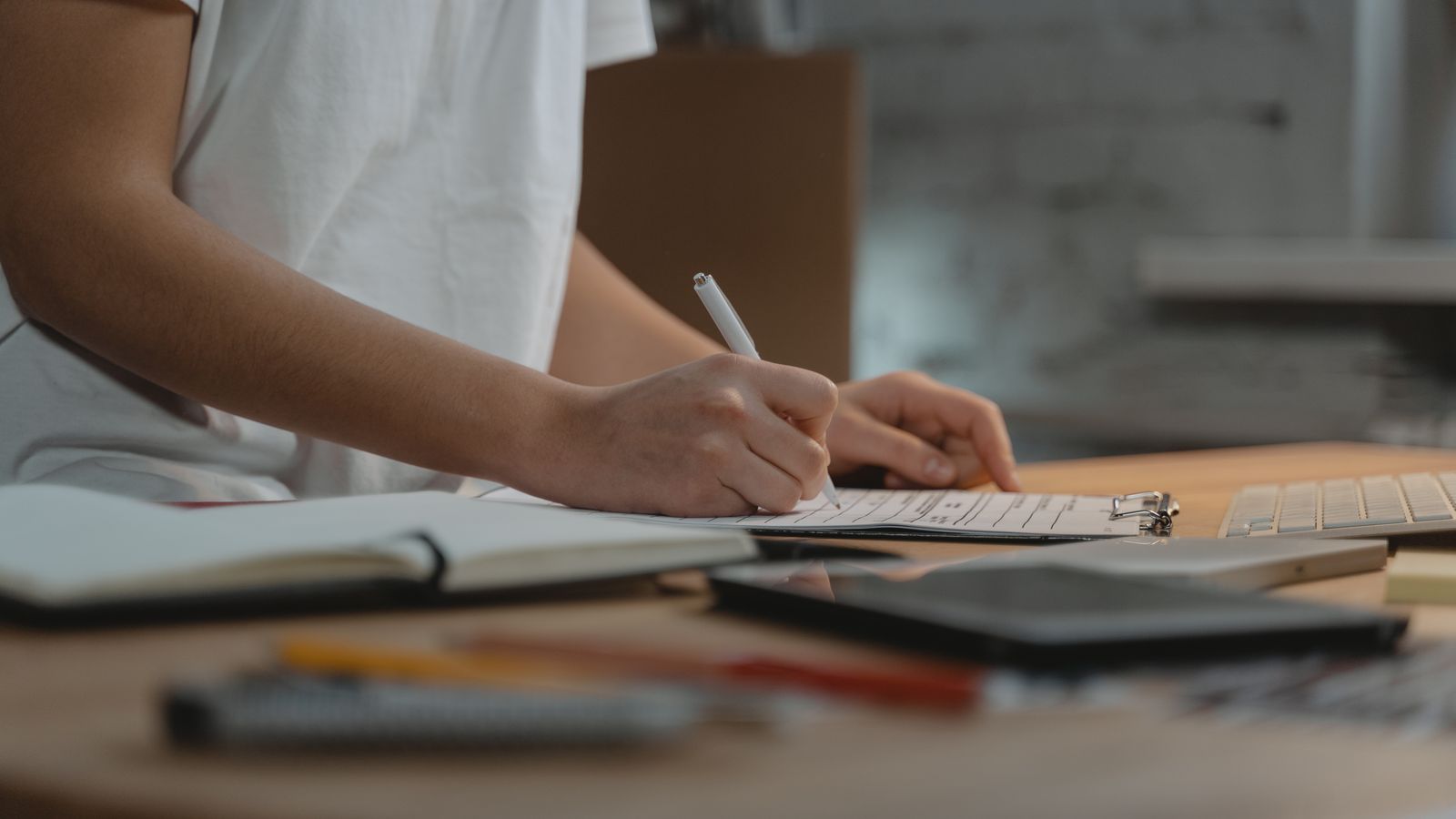 Person organising administrative documents on a desk ahead of a deadline